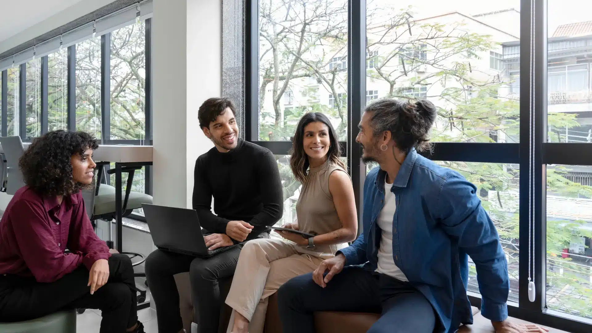 Profesionales conversando en el lugar de trabajo durante la evaluación de factores de riesgo psicosocial en una empresa en Colombia.